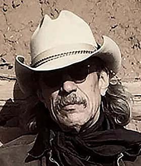 Headshot of Jim Arndt in light-colored, small brimmed cowboy hat with a dark bandana.