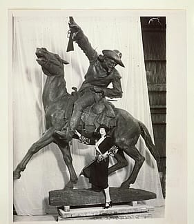 Gertrude Vanderbilt Whitney standing beside her sculpture, Buffalo Bill – The Scout, circa 1923.