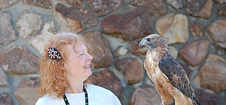 Volunteer Anne with red-tailed hawk Isham.