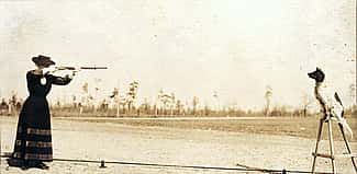 Annie Oakley plans to shoot an apple off the head of her dog Dave in this postcard image. P.94.1