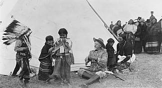 Buffalo Bill takes time to play with young American Indian children whose parents were more than likely actors in his Wild West, ca. 1913. MS 6 William F. Cody Collection. P.6.243