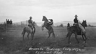 Arthur Holman bronc riding at Stampede Rodeo, Clarence William at left, Blocker Dodge at right. MS 005 Cody Local History Collection. P.69.1703