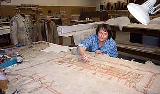 Beverly Perkins treats a painted hide in the Center's conservation laboratory.