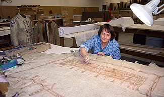 Beverly Perkins treats a painted hide in the Center's conservation laboratory.