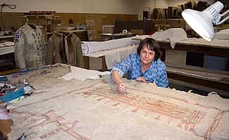 Buffalo Bill Center of the West Conservator Beverly Perkins works on a painted hide from the Plains Indian Museum collection.