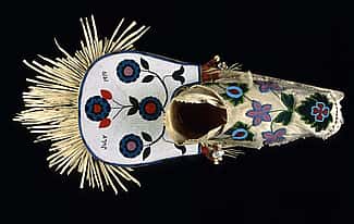Cradleboard, Salish, Plateau 1919. Wood, tanned hide, muslin, glass beads, cowrie shells, abalone shells, mother of pearl, brass Simplot Collection, Gift of J.R. Simplot; NA.111.57