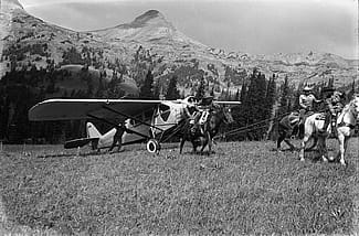 Lucille Nichols, on her father's white horse, leads riders tugging on Bill Monday's plane. MS3 Charles Belden Collection. PN.67.838b