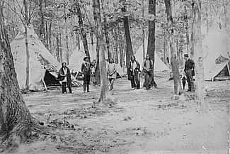 Wild West's Buck Taylor with the show's Indian encampment on Erostina Staten Island, ca. 1888. MS 006 William F. Cody Collection, McCracken Research Library. P.6.201