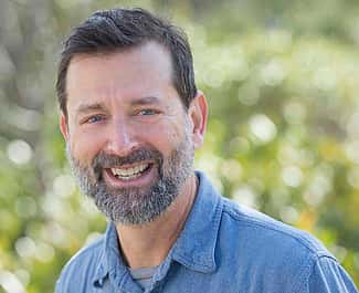 Dr. Scott Wing, blue shirt, greenery background. Photo by Jame Kegley for the Smithsonian.