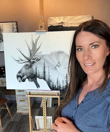Maggie Bassett poses with her charcoal art of a moose.