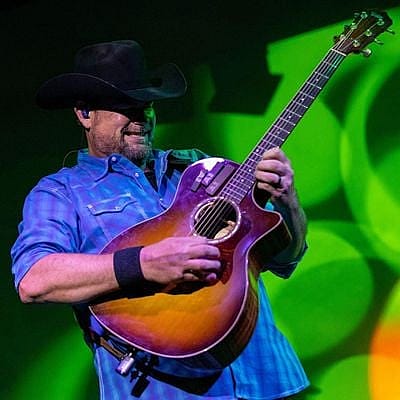Ryan Martin playing guitar at the Cody Cattle Company Dinner Show.