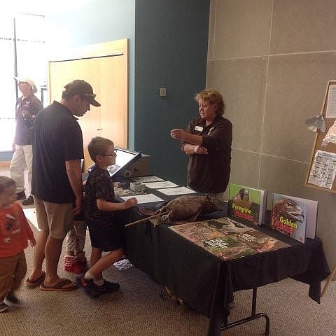Lynn manning the Learning Table with lots of items to touch and read.