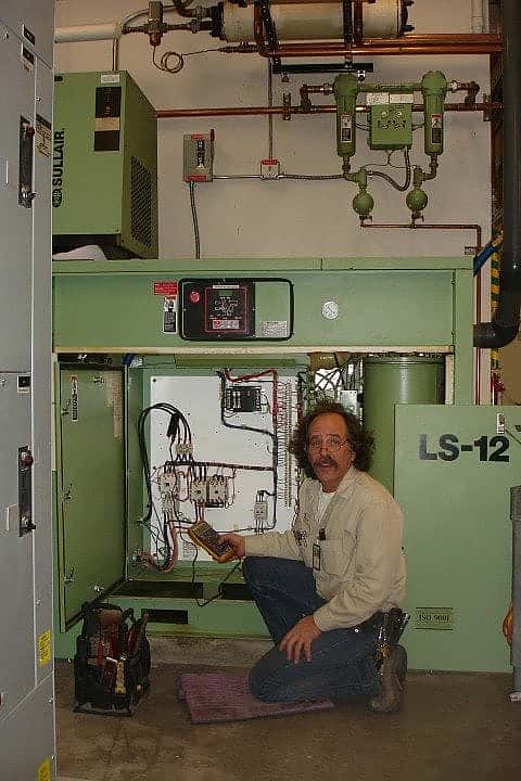 Phil with the Facilities air compressor. Note the shell-and-tube heat exchangers at top border of the image.