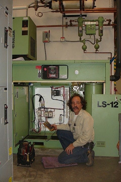 Phil with the Facilities air compressor. Note the shell-and-tube heat exchangers at top border of the image.