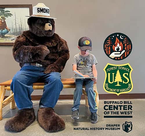 Smokey Bear mascot visits with young boy.