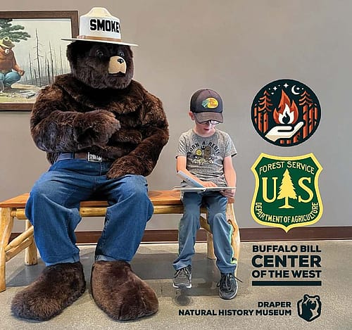 Smokey Bear mascot visits with young boy.