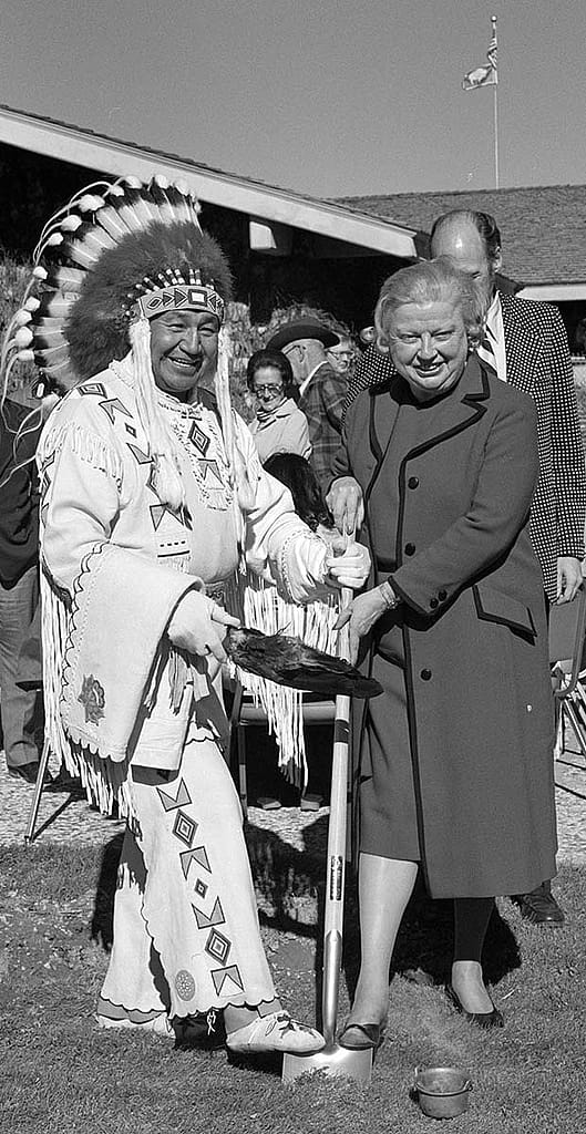 Fig. 11: Plains Indian Museum groundbreaking, October 12, 1977, with Blackfeet member of the first Plains Indian Museum Advisory Board Peter Red Horn, Margaret "Peg" Coe, and Al Simpson standing behind. MS 089 Jack Richard Photograph Collection, McCracken Research Library. PN.89.79.13527.12 (detail)