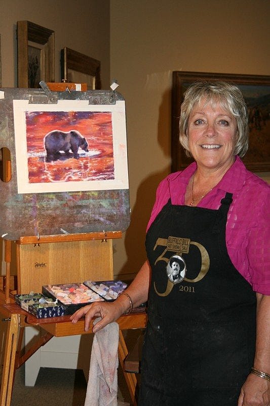 Julie Oriet stands next to one of the pastels she created on site during her residency.