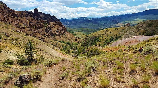 Landscape of mountains, trail, and sky. BLM Wyoming photo; Creative Commons.