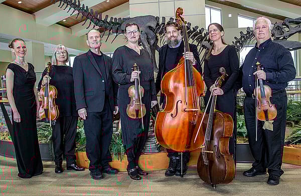 Seven members of Wyoming Baroque dressed in black, five of them holding stringed instruments.