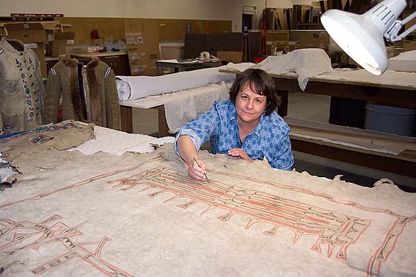 Beverly Perkins treats a painted hide in the Center's conservation laboratory.