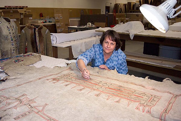 Beverly Perkins treats a painted hide in the Center's conservation laboratory.