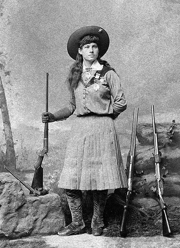 Annie Oakley poses with rifles and pistol. MS6 William F. Cody Collection, McCracken Research Library. P.69.1164