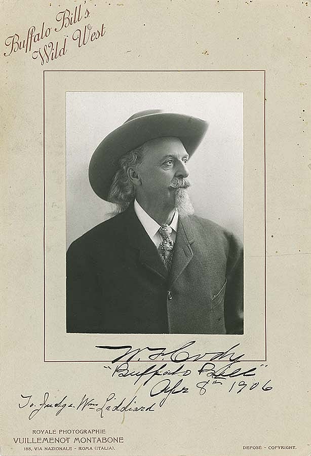Formal portrait of Buffalo Bill Cody from 1906, featuring him in a suit and hat, with autograph, under the title "Buffalo Bill’s Wild West.