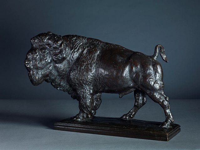 Bronze sculpture of a bison captured from a rear-side angle, emphasizing its powerful build, curved tail, and intricate fur details on a sturdy rectangular base.