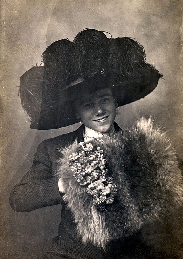Teasing his sisters, Cody Bell tries on his mother's hat and muff for the camera, about 1910. Cody told a journalist, "It gets annoying to be always mistaken for a girl...but I keep them guessing all the time." MS 294 Bell Family Collection. P.294.24