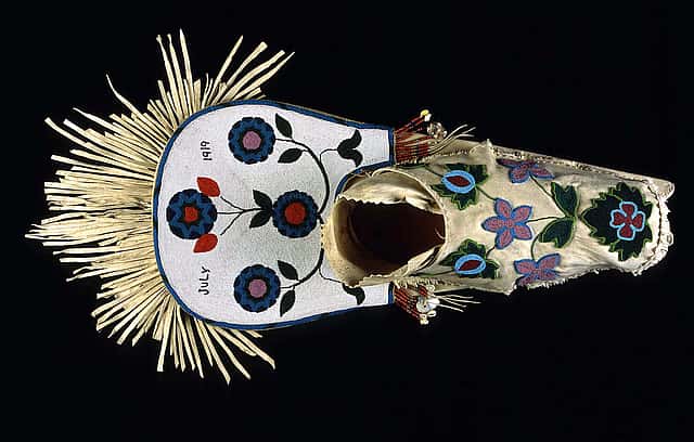 Cradleboard, Salish, Plateau 1919. Wood, tanned hide, muslin, glass beads, cowrie shells, abalone shells, mother of pearl, brass Simplot Collection, Gift of J.R. Simplot; NA.111.57