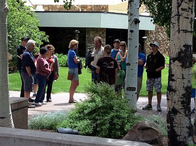 Crowd gathered around woman with peregrine falcon.