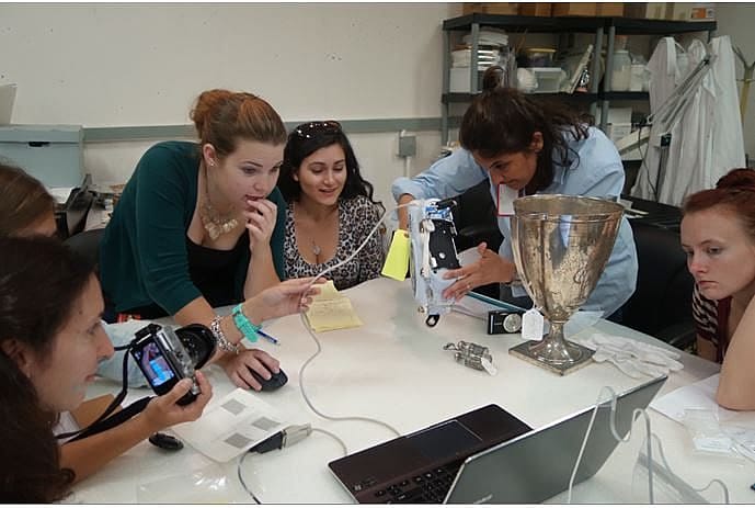 The group collecting data as fellow intern Christiana Ginatta analyses an object.