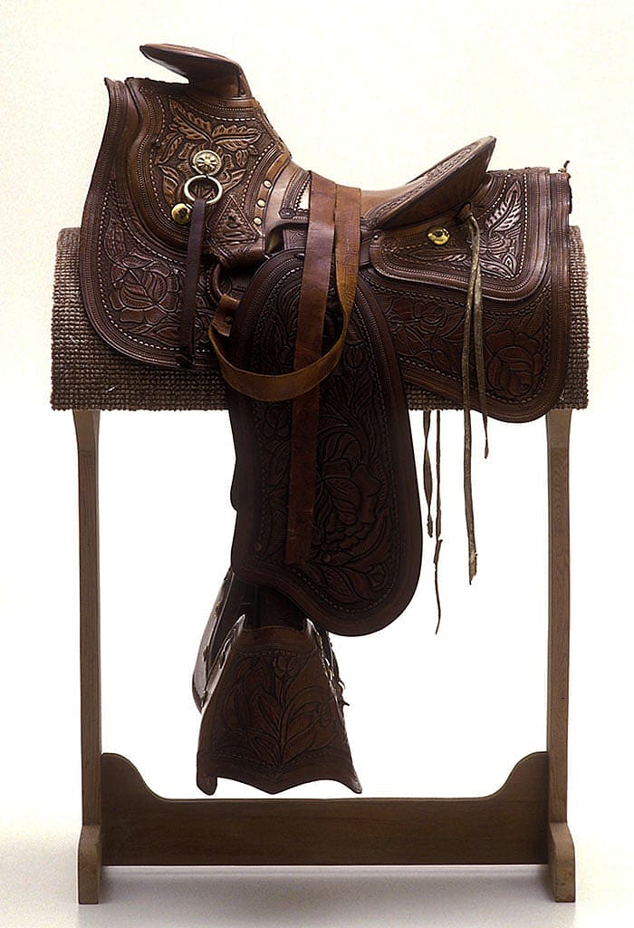 This A-frame saddle with tapaderos was made between 1850 and 1890. Note the carving style. These earlier patterns incorporated large floral elements. Gift of the Coe Foundation. 1.67.331