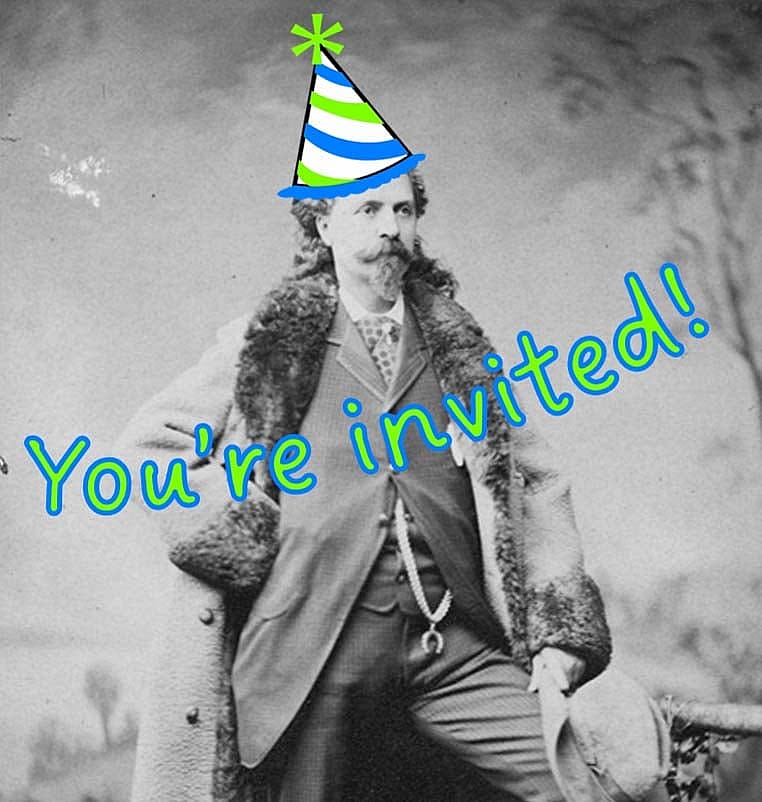 A portrait of Buffalo Bill standing in front of a painted backdrop. He wears a full length fur trimmed coat, a three piece suit and a gold chain with horseshoe pendant. He has one leg up on a block and holds his hat over his knee. P.6.0124