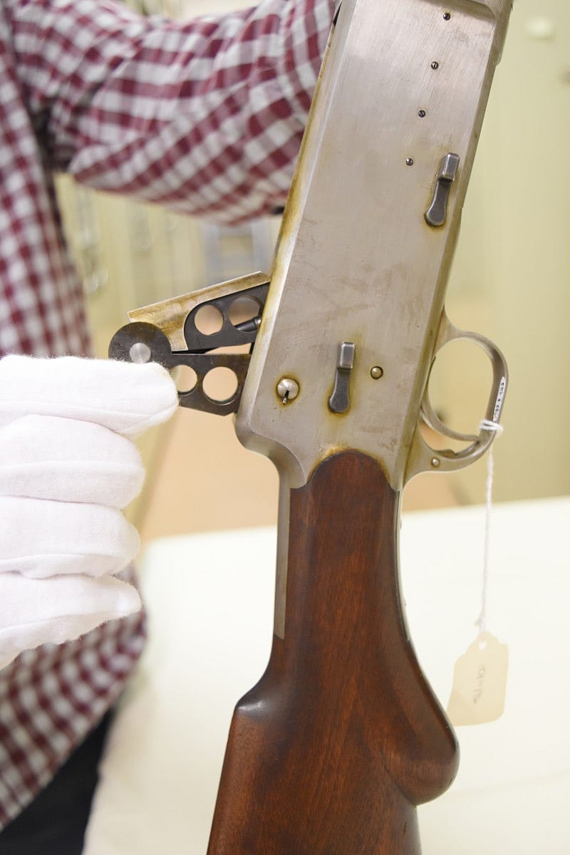 The shotgun's action open. It has to be held open. The holes milled through the bolt serve to either lighten it or perhaps could have had weights fitted into them for different shot shell loads.