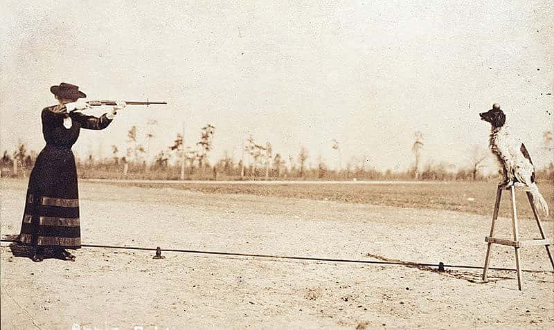 Annie Oakley plans to shoot an apple off the head of her dog Dave in this postcard image. P.94.1