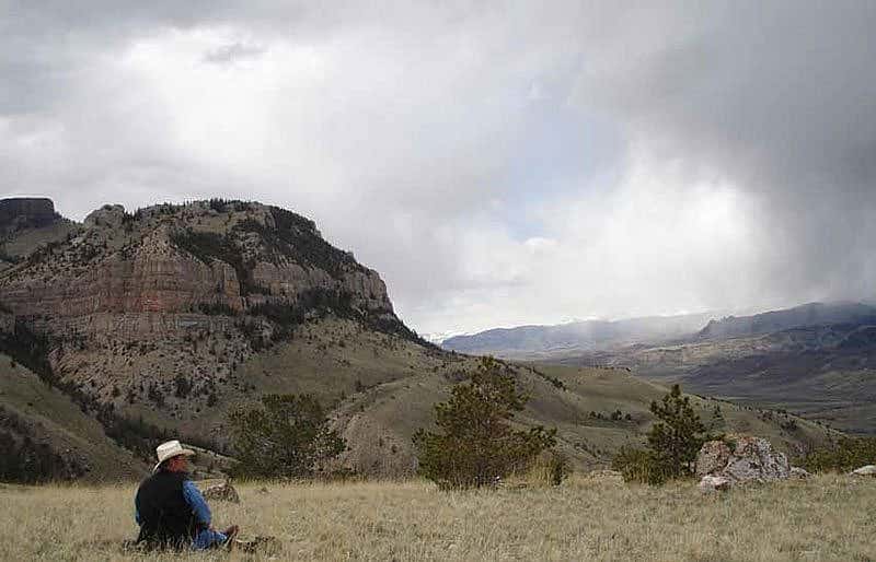 Research Assistant Richard Jones monitors a Golden Eagle nest on the distant ledge.