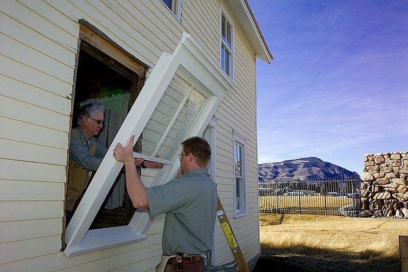Center carpenters installing restored windows.