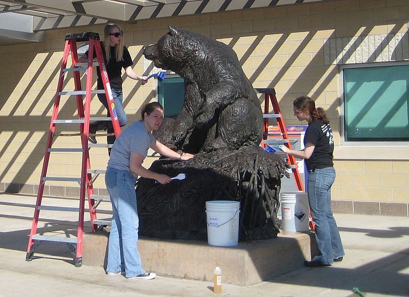 Interns in the Center's Conservation Residency program clean "Big Hal," a sculpture on loan to Yellowstone Regional Airport. "Big Hal" by Michael Coleman, modeled 2002, cast 2003. Gift of Jim and Kathy Taggart. 6.04