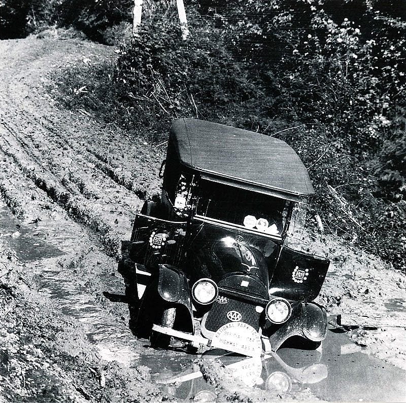 National Park-to-Park official car in mudhole, ca. 1920s.