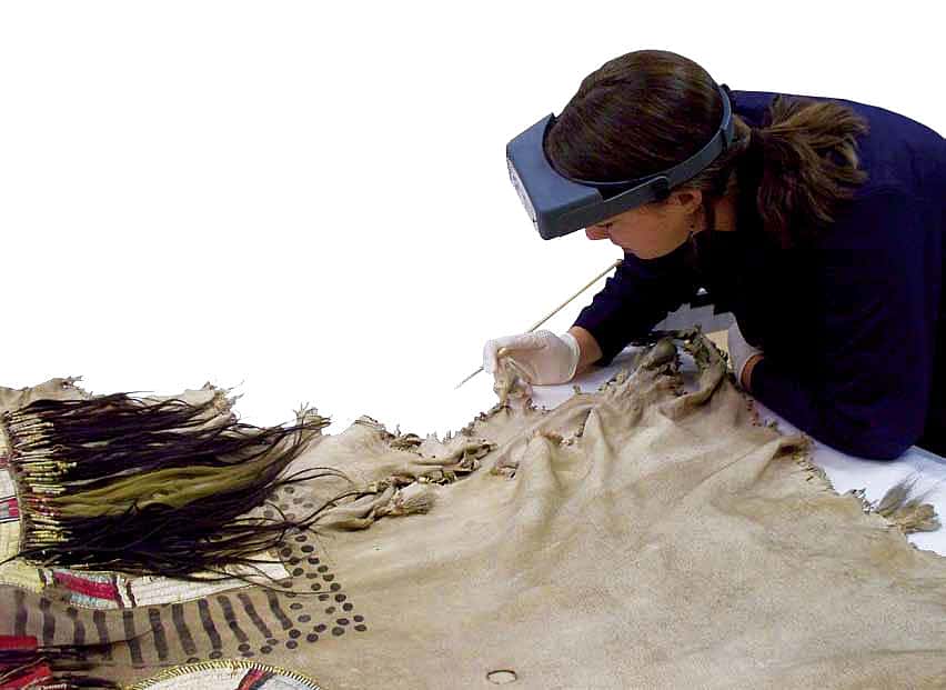 Tara Griffin, who served as a conservation intern in 2010, begins her work with a close examination of an artifact from the Paul Dyck Plains Indian Buffalo Culture Collection. Man's shirt, Upper Missouri River, ca. 1840s. The Paul Dyck Plains Indian Buffalo Culture Collection, acquired through the generosity of the Dyck family and additional gifts of the Nielson Family and the Estate of Margaret S. Coe. NA.202.1218