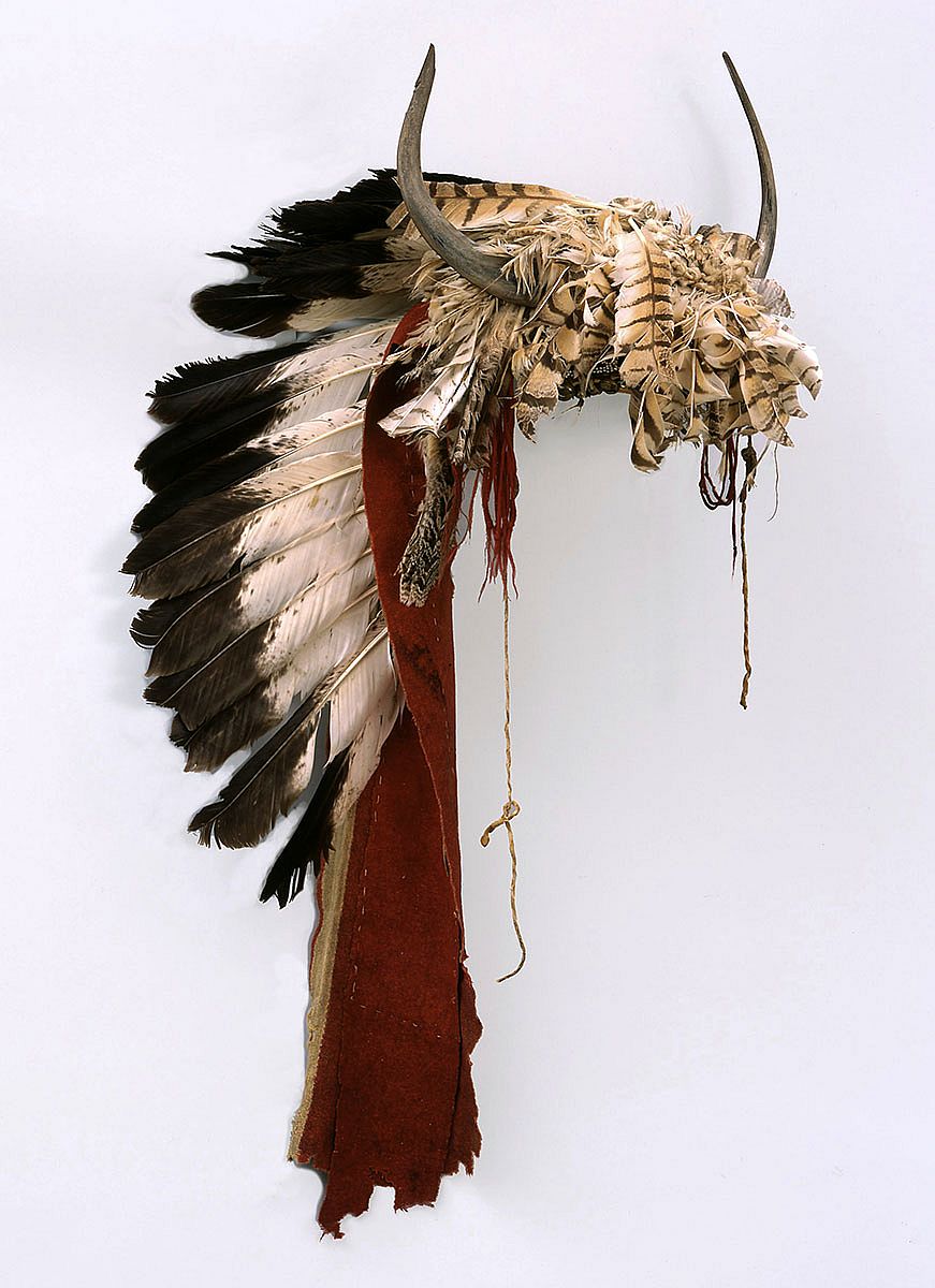 Buffalo horn bonnet, ca. 1860. Northern Plains, Crow. Feathers, wool, glass beads, bells, deer hide, brass, buffalo, eagle, horns. Catherine Bradford McClellan Collection, Gift of The Coe Foundation. NA.203.18