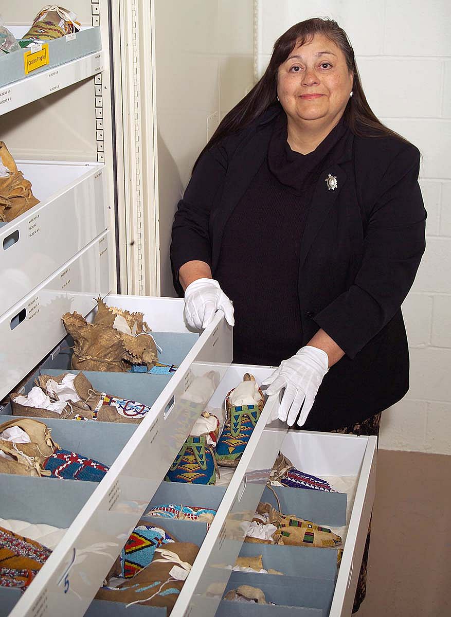 Plains Indian Museum Curator [now Curator Emerita] Emma Hansen reviews the museum's moccasins, carefully stored to prevent damage.