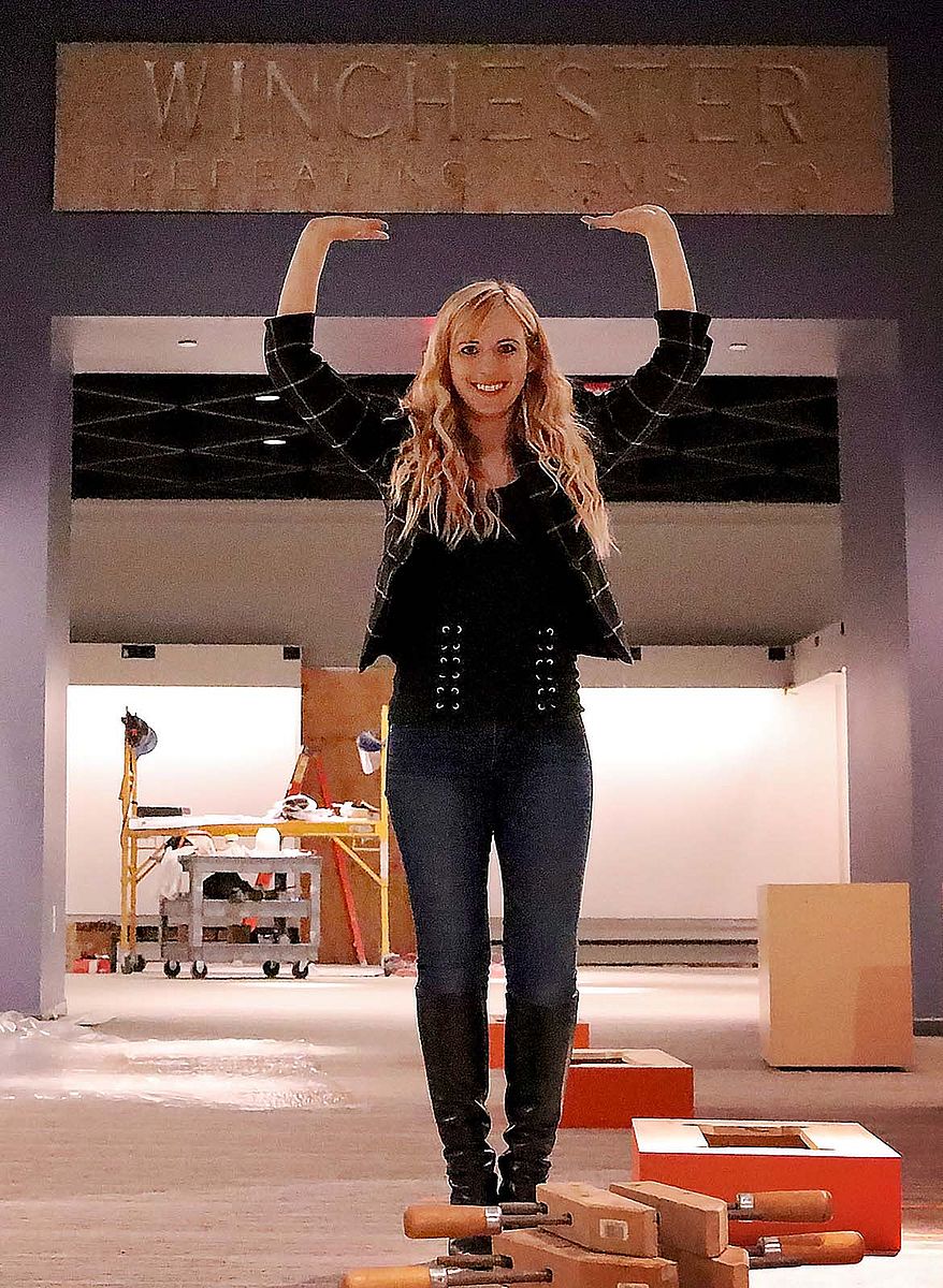 Ashley Hlebinsky ably "supports" the Winchester Repeating Arms Co. factory lintel after its installation in the new Cody Firearms Museum.