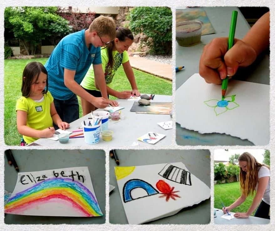 Children participate in outdoor art activities during Family Fun Day, drawing with crayons and painting creative designs at the Buffalo Bill Center.