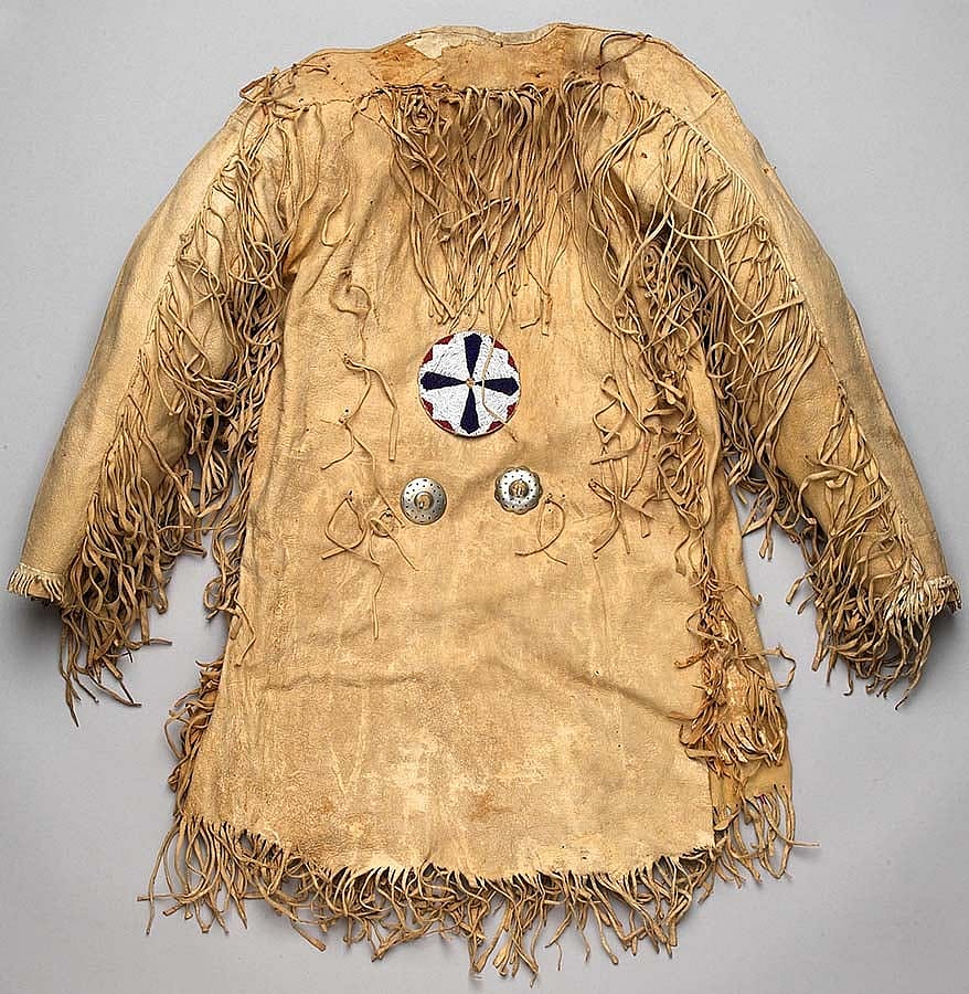 Mountain man's fringe leather jerkin shirt decorated with two nickel conchas and a large beaded rosette, undated. Gift of Richard W. Leche. NA.202.588