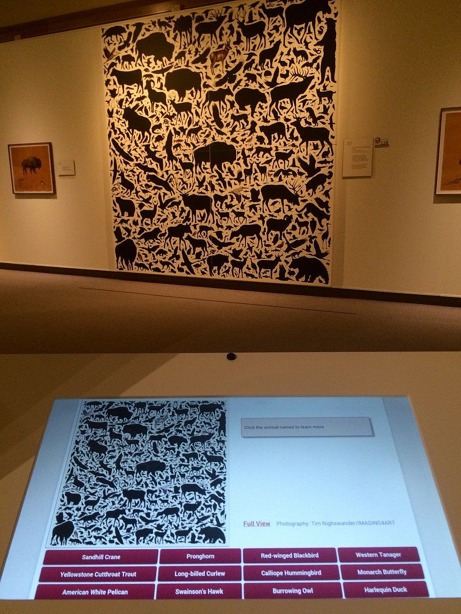  Interactive exhibit featuring James Prosek's artwork at the Whitney Western Art Museum, with a digital display and large black-and-white mural.