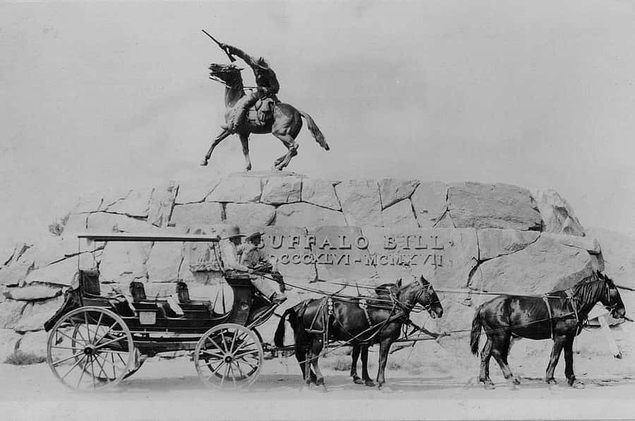 A coach stops in front of the statue "Buffalo Bill - The Scout" by Gertrude Vanderbilt Whitney, ca. 1924–1940. MS 327 James Wojtowicz Collection, McCracken Research Library. MS 327.07.29.001.01