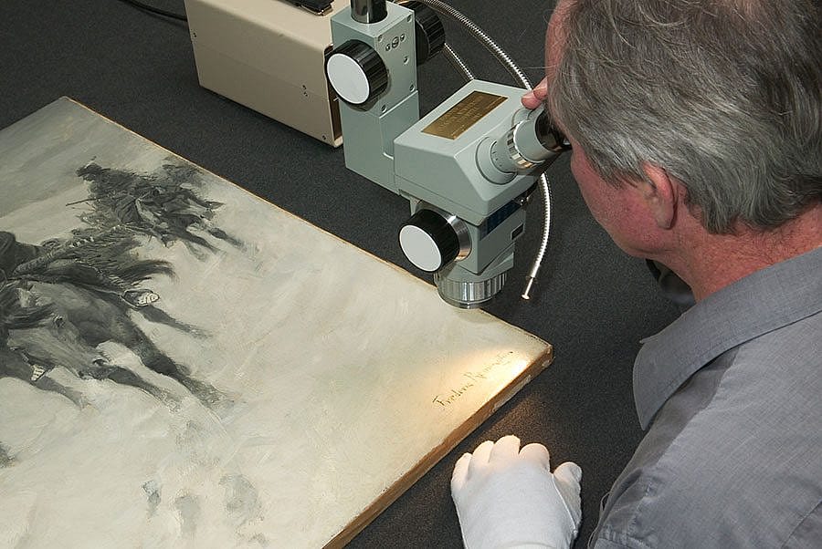 Illustration 4: Glenbow Museum painting conservator Don Murchison examines the signature under the microscope.